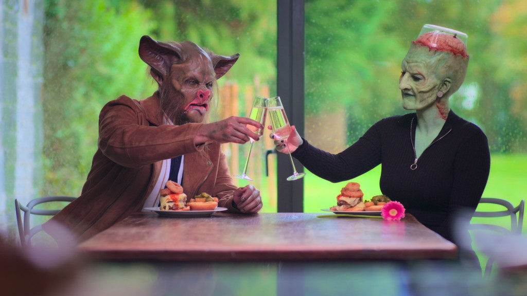 Two people caked in masks and animal makeup toast champagne glasses while on a date. 