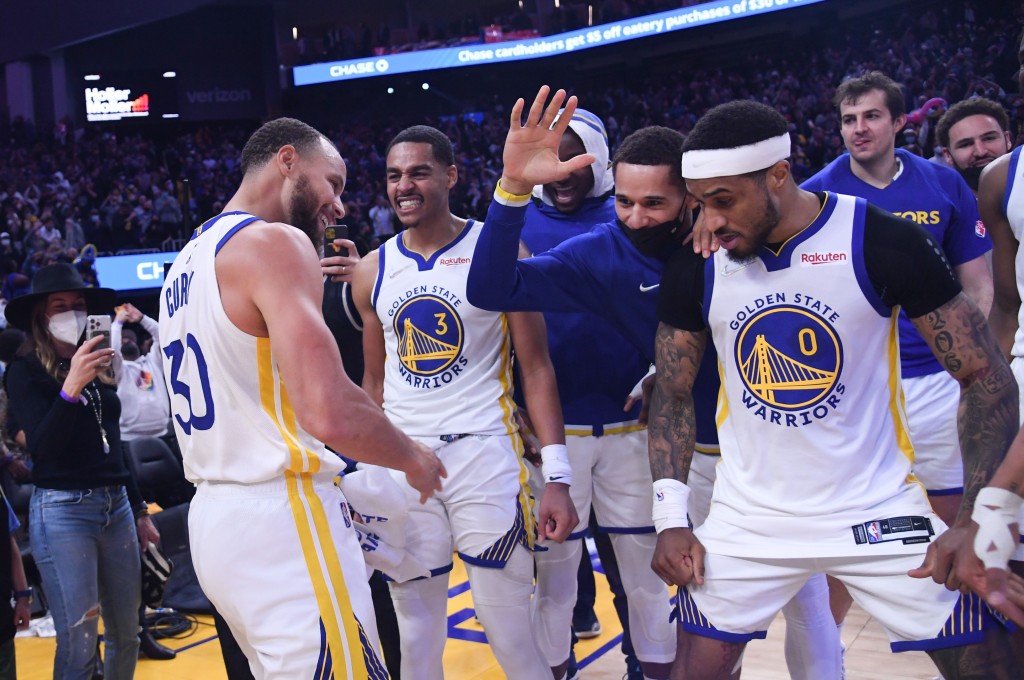 Steph Curry celebrates with teammates.