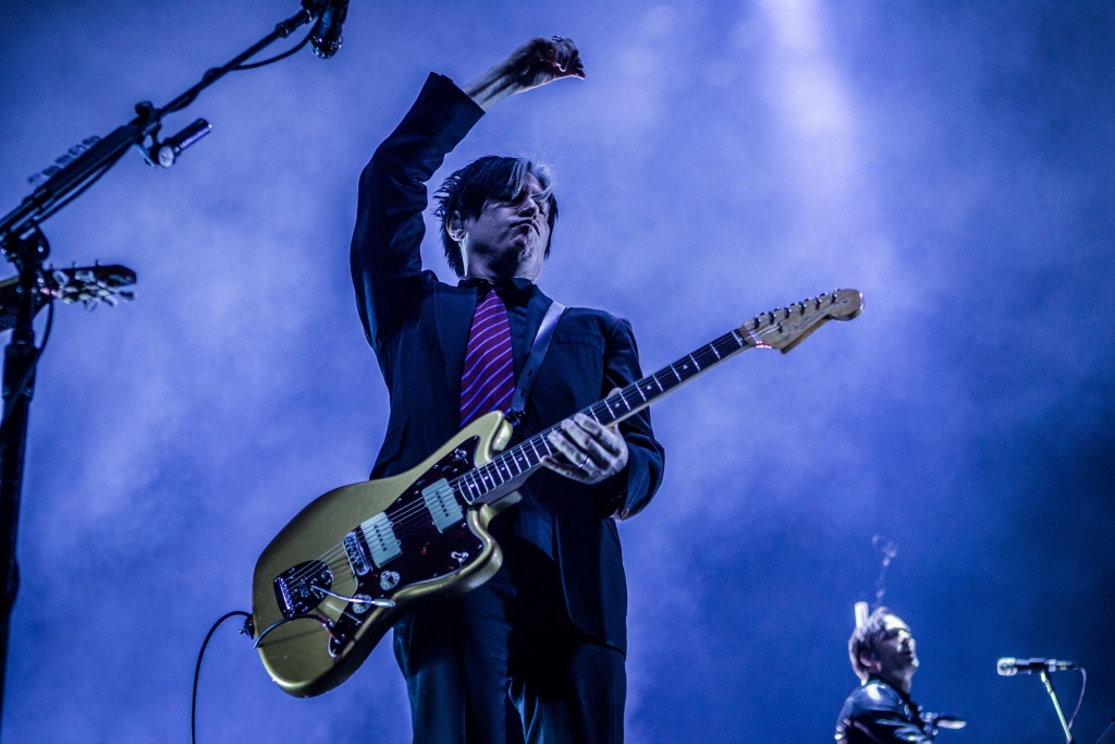 A photo of Queens of the Stone Age guitarist Troy Van Leeuwen on stage